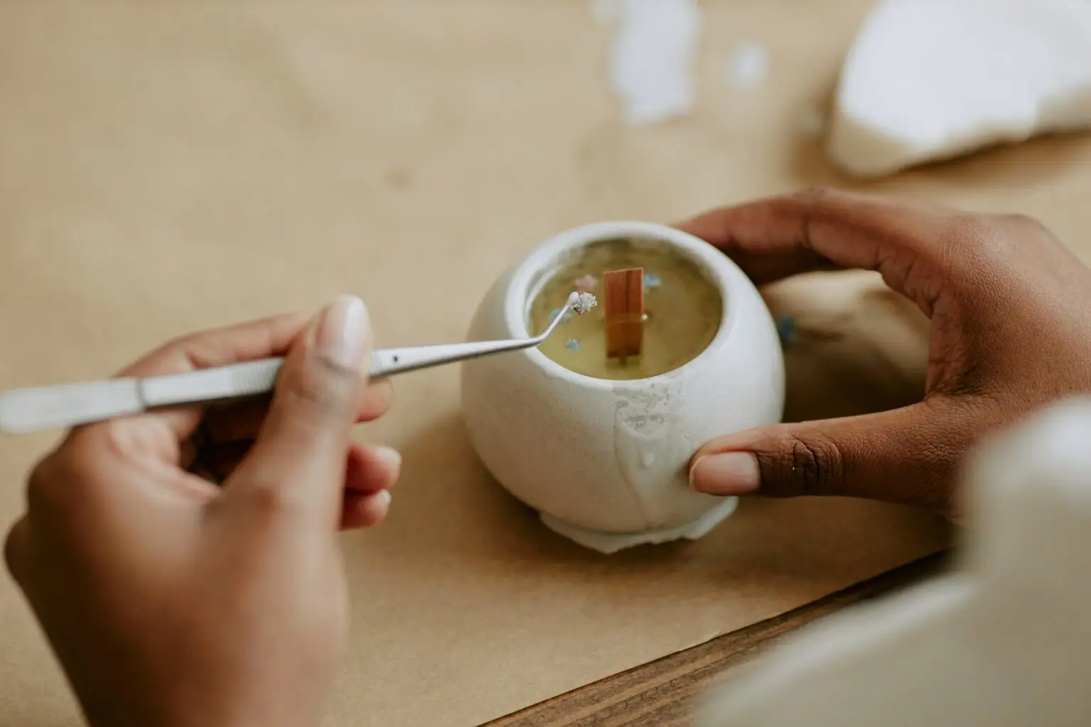 A maker finishing a candle by hand